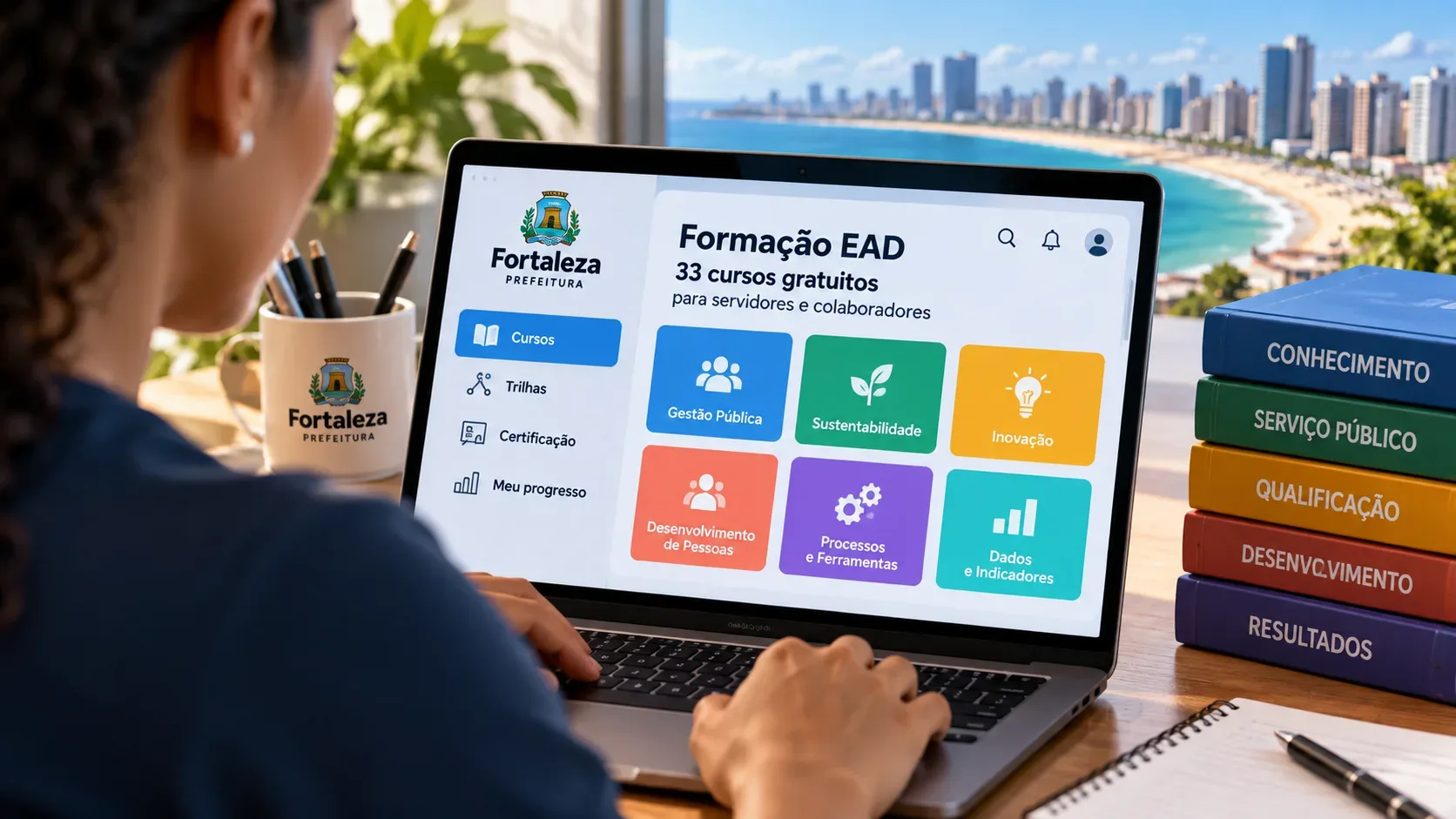 Pessoa usando notebook com interface de formação EAD da Prefeitura de Fortaleza, livros de capacitação ao lado e a orla da cidade ao fundo.